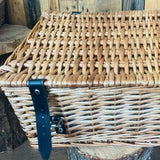 Wicker basket with a blue strap on a wooden surface