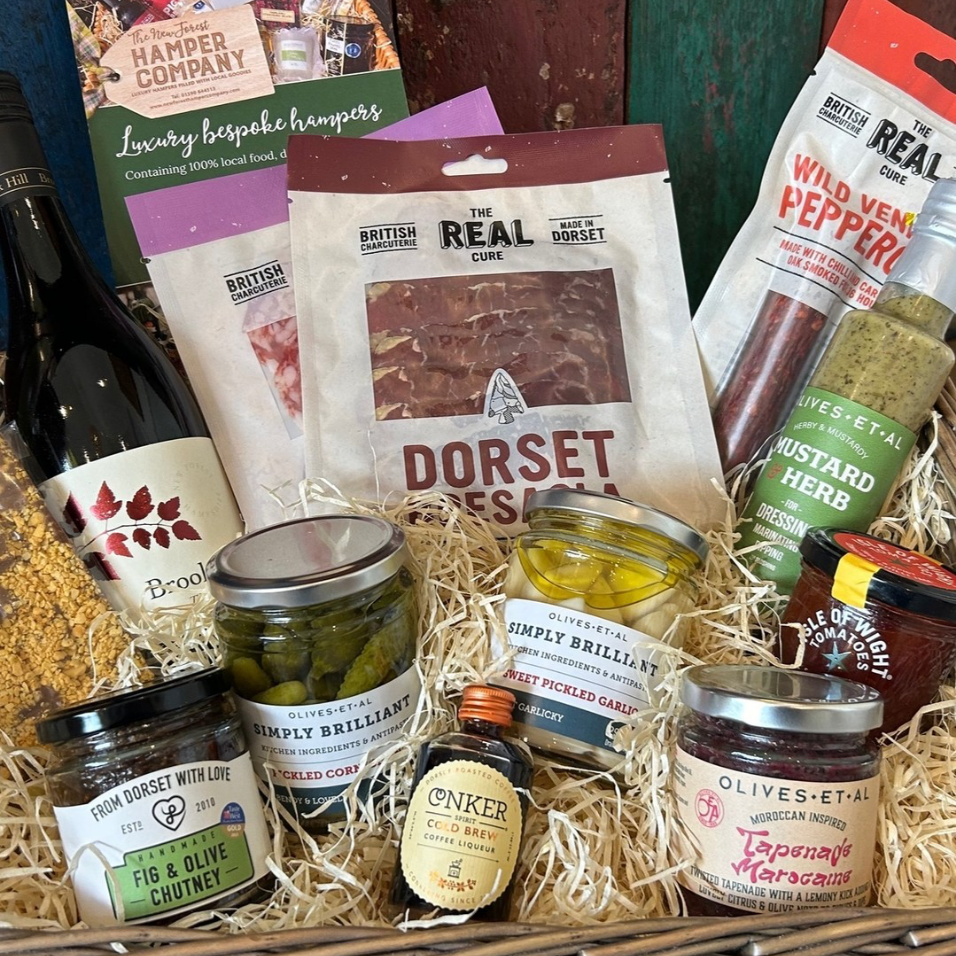 Gourmet gift basket with various food items including meats, cheeses, and condiments.