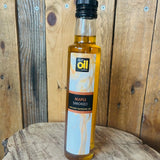 Bottle of maple smoked oil on a wooden surface with a wooden background