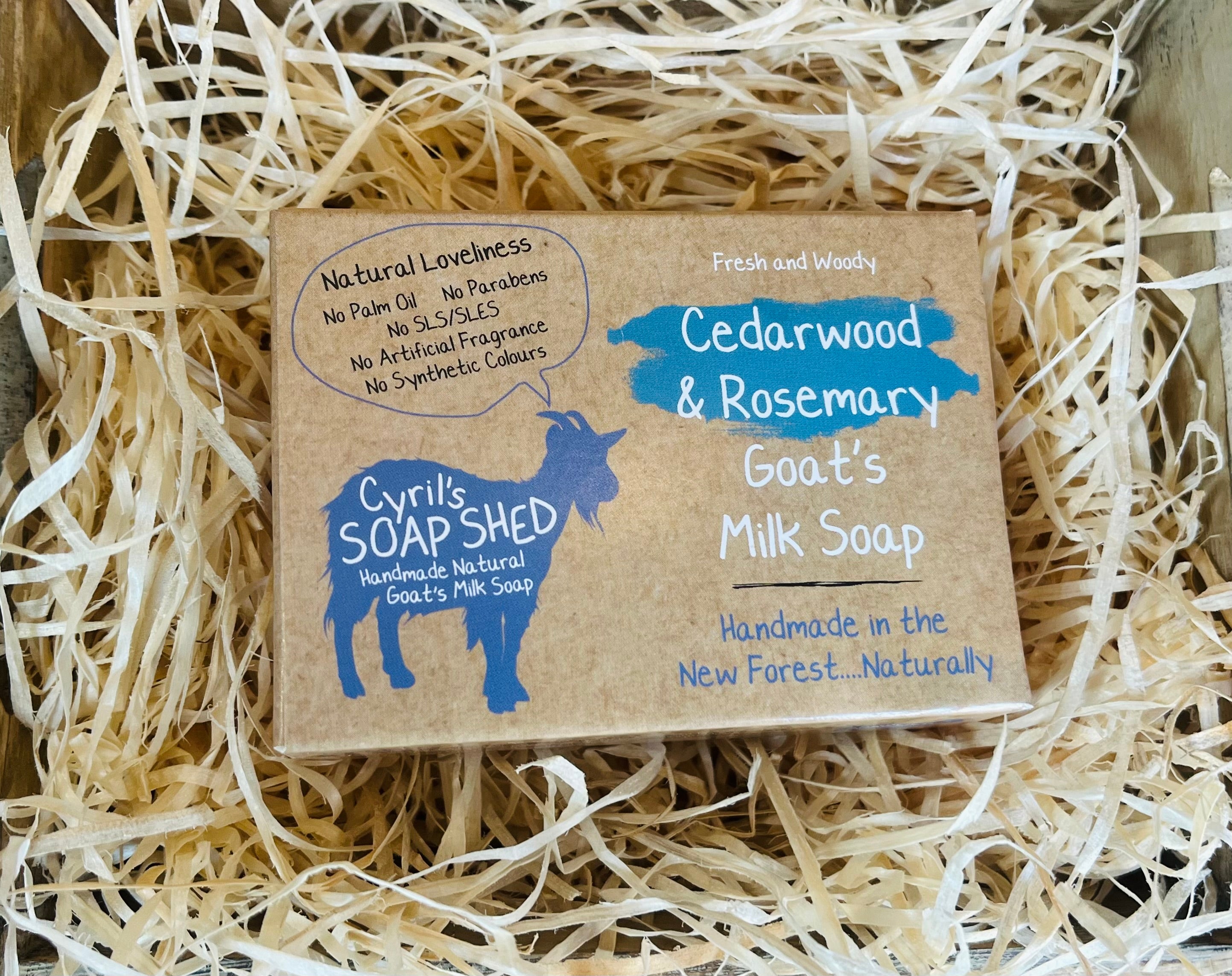 Goat's milk soap bar with Cyril's Soap Shed branding on a bed of straw.