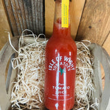 Red bottle of Isle of Wight Tomatoes tomato juice on a wooden background