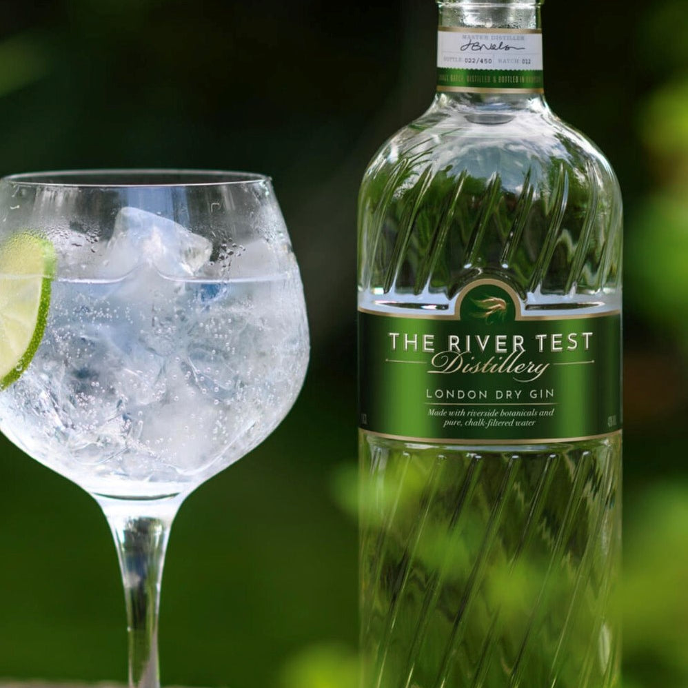Bottle of The River Test London Dry gin with a glass of gin and tonic on a natural background