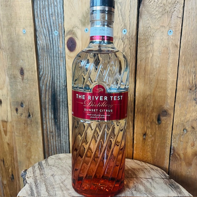 Bottle of 'The River Test Distillery Sunset Citrus' on a wooden barrel with a wooden background