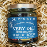 Jar of olives with a blue label on a bed of straw