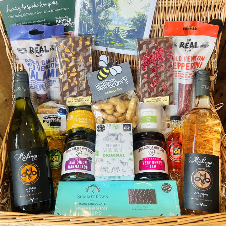 Gourmet gift basket with various items including wine, chocolate, and snacks.