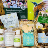 Gift basket with various products including candles, body lotion, and honey, branded 'New Forest'.
