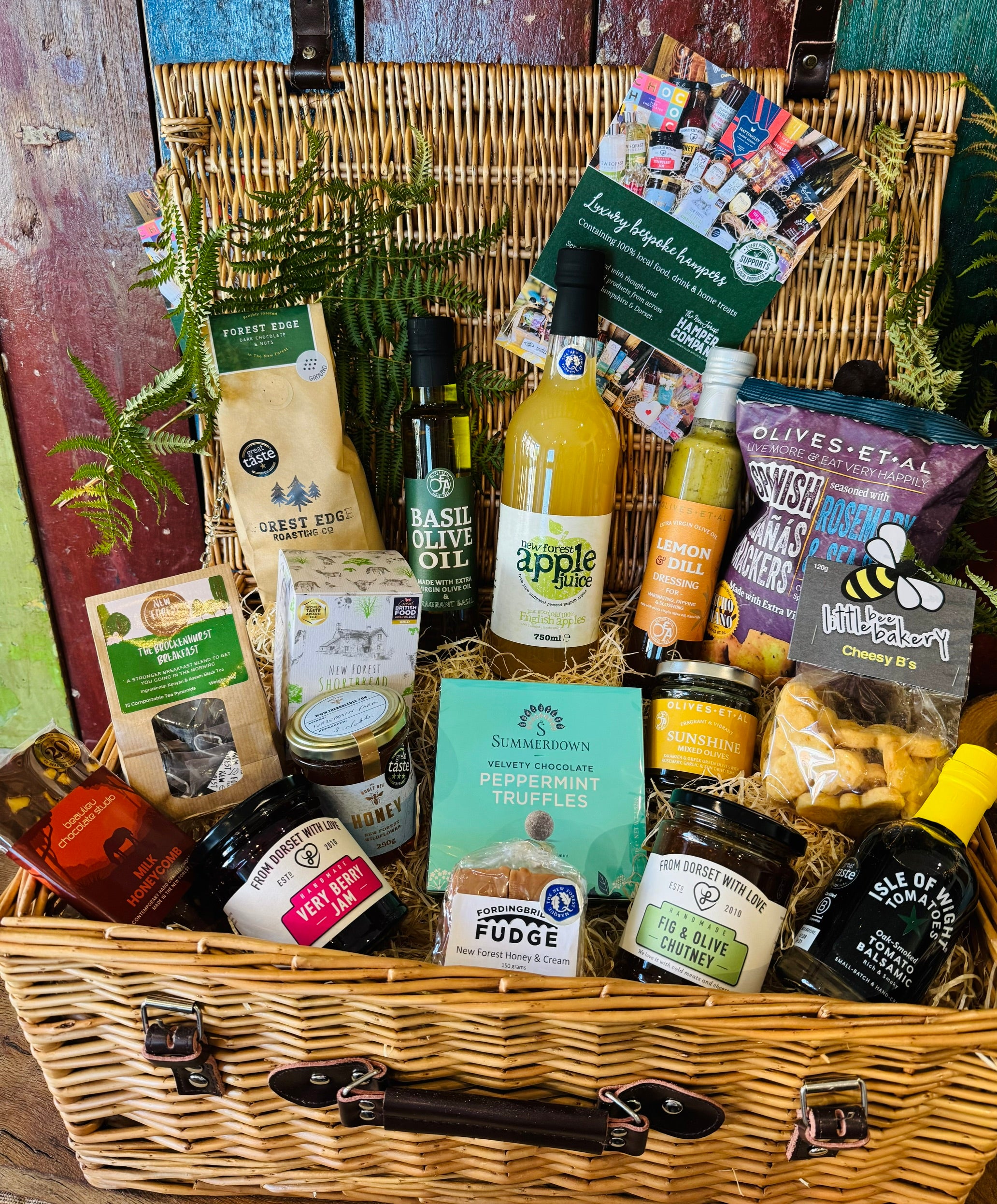 The Local Pantry Hamper, an alcohol-free and vegetarian New Forest gift hamper showing Fordingbridge Fudge, From Dorset With Love Very Berry jam and Fig & Olive chutney, Isle of Wight oak-smoked tomato balsamic and Little Bee Bakery Cheesy B's