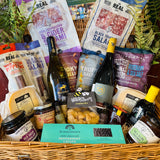 The Indulgent Wine, Cheese & Charcuterie Hamper - a 20 inch lidded willow basket with B58 Red and Danebury white wine, four Real Cure Dorset salamis, two Lyburn cheeses, olives, crackers and chutneys