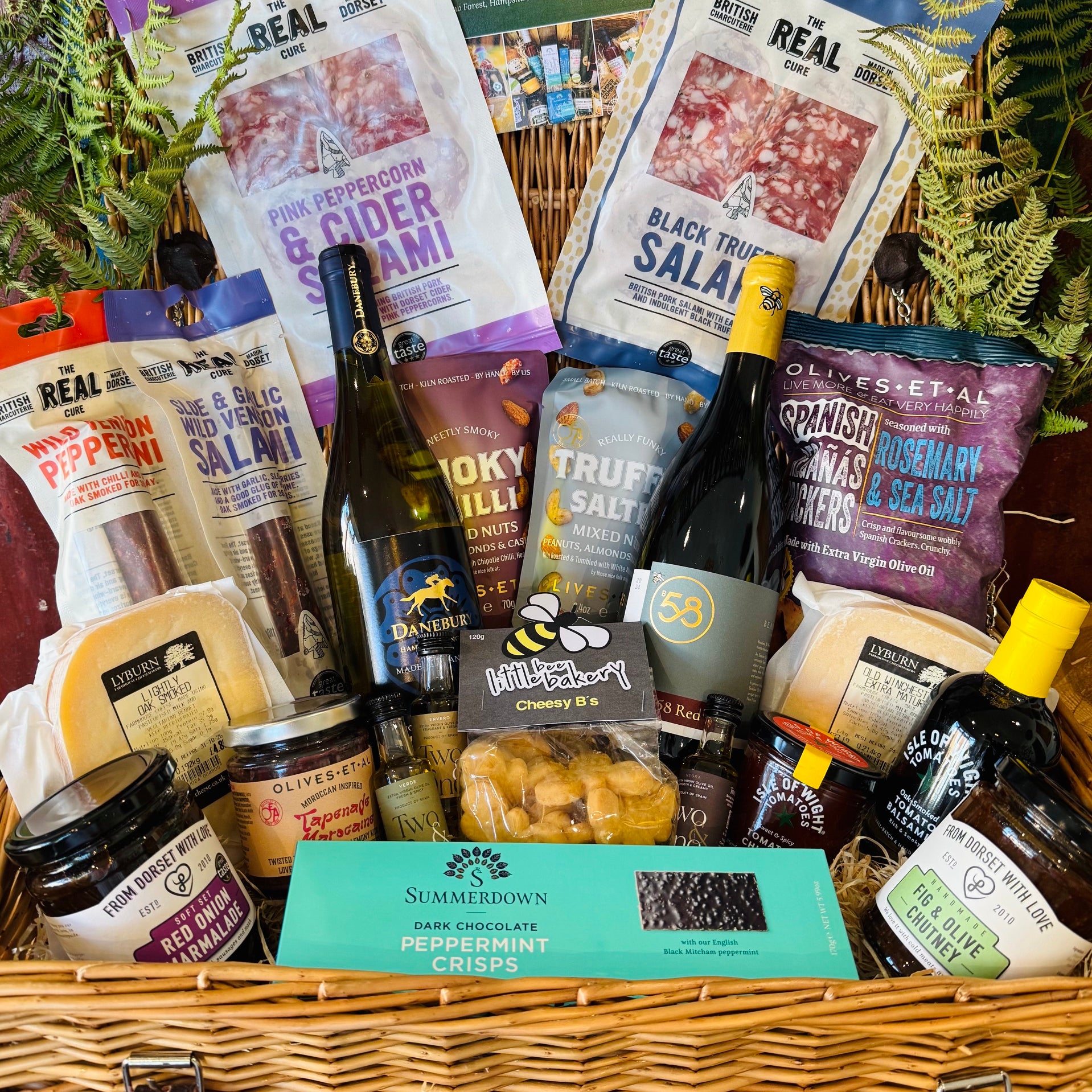 The Indulgent Wine, Cheese & Charcuterie Hamper - a 20 inch lidded willow basket with B58 Red and Danebury white wine, four Real Cure Dorset salamis, two Lyburn cheeses, olives, crackers and chutneys