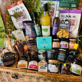 The Ultimate Hampshire & Dorset Goodies Hamper - a 24 inch lidded willow basket filled with Real Cure charcuterie, cheese biscuits, olives, local preserves, Beaulieu chocolate, New Forest apple juice and a Noble Bee beeswax candle