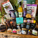 The Ultimate Hampshire & Dorset Goodies Hamper from above - twenty-nine items including Summerdown peppermint truffles, chocolate dipped giant pretzels, New Forest Shortbread and Brockenhurst Breakfast tea in a 24 inch willow basket