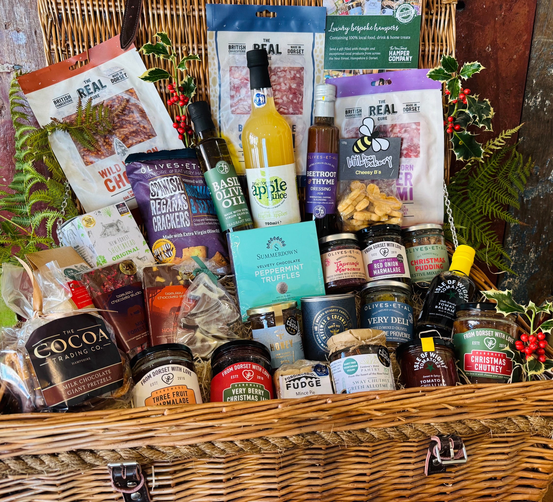 Close view of the Ultimate Christmas Goodies Hamper showing Christmas chutney, three fruit marmalade, Very Berry Christmas jam, Sway Chutney, tomato and chilli jam and New Forest wildflower honey