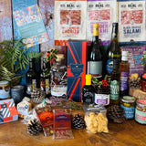 The Ultimate Hampshire & Dorset Christmas Hamper in display format - Hattingley Valley Classic Reserve, B58 red, Danebury Madeleine Angevine, 820 Spirits London Dry Gin and two Downton Brewery ales with four Real Cure salamis, Chococo festive chocolates, Olives et Al preserves and the 24 inch willow basket