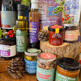 Festive sweet selection from The Ultimate Hampshire & Dorset Christmas Hamper - Chococo Festive Collection, Beaulieu Chocolate Studio milk honeycomb and forest fruit bars, New Forest shortbread, Fordingbridge mince pie fudge and a Noble Bee candle, dressed with pine cones and heather