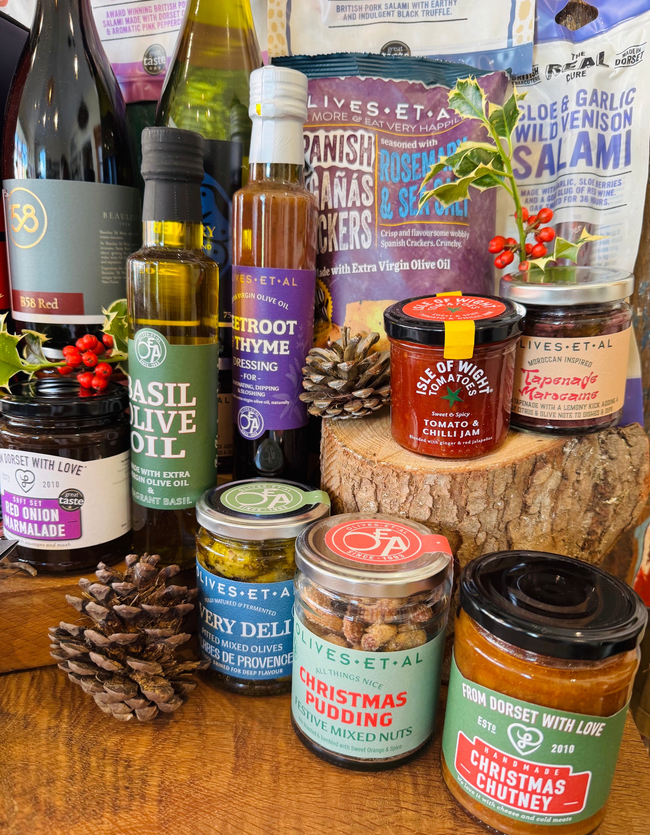 Festive sweet selection from The Ultimate Hampshire & Dorset Christmas Hamper - Chococo Festive Collection, Beaulieu Chocolate Studio milk honeycomb and forest fruit bars, New Forest shortbread, Fordingbridge mince pie fudge and a Noble Bee candle, dressed with pine cones and heather