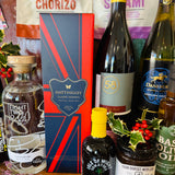 Thirty-item display of The Ultimate Hampshire & Dorset Christmas Hamper - English sparkling wine, red and white wine, New Forest gin, two local ales, Real Cure charcuterie, cheese biscuits and Spanish crackers, olives, tapenade, festive preserves, chocolates and a candle