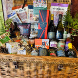 The Ultimate Hampshire & Dorset Christmas Hamper - a 24 inch lidded willow basket with Hattingley Valley sparkling wine, B58 and Danebury wines, 820 Spirits gin, Downton ales, Real Cure charcuterie, Chococo festive chocolates and Christmas preserves, dressed with fern and holly