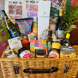 The Indulgent Celebration Hamper - a 20 inch lidded willow basket with Chalkdown sparkling, Danebury and B58 wines, 820 Spirits gin, Dorset charcuterie, chocolates and New Forest preserves