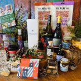Everything in the Chalkdown Fizz & Festive Goodies Hamper laid out: four bottles, Dorset salami, preserves and Christmas chocolates