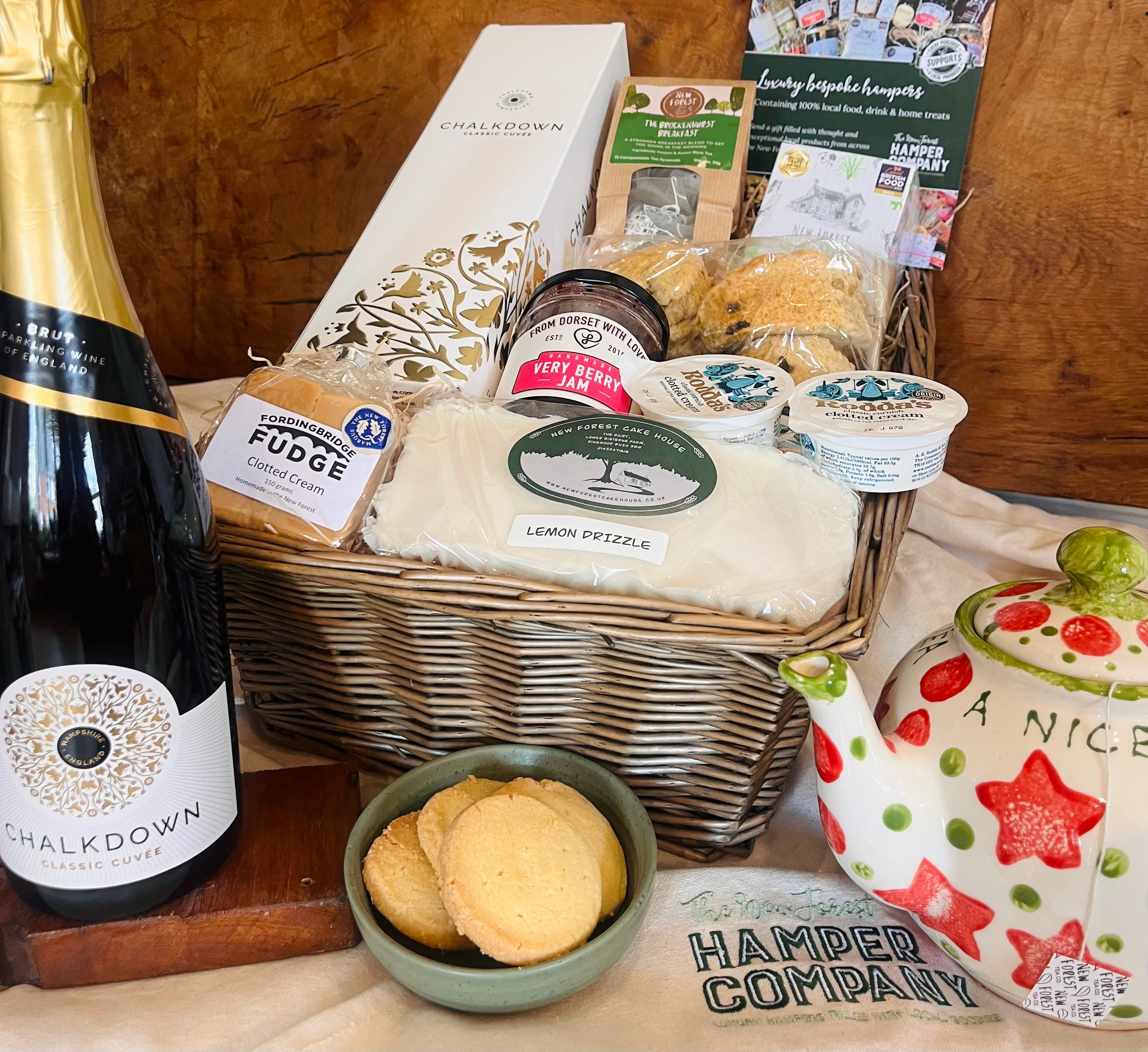 Chalkdown Afternoon Tea Hamper in an extra large antique willow basket with Chalkdown Classic Cuvée English sparkling wine, fruit scones, Rodda's clotted cream, lemon drizzle cake, New Forest Shortbread, Very Berry jam, clotted cream fudge and Brockenhurst Breakfast tea