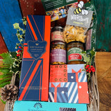 The Hattingley Festive Indulgence Hamper packed in its extra-large antique willow basket with holly, ferns and pine cones