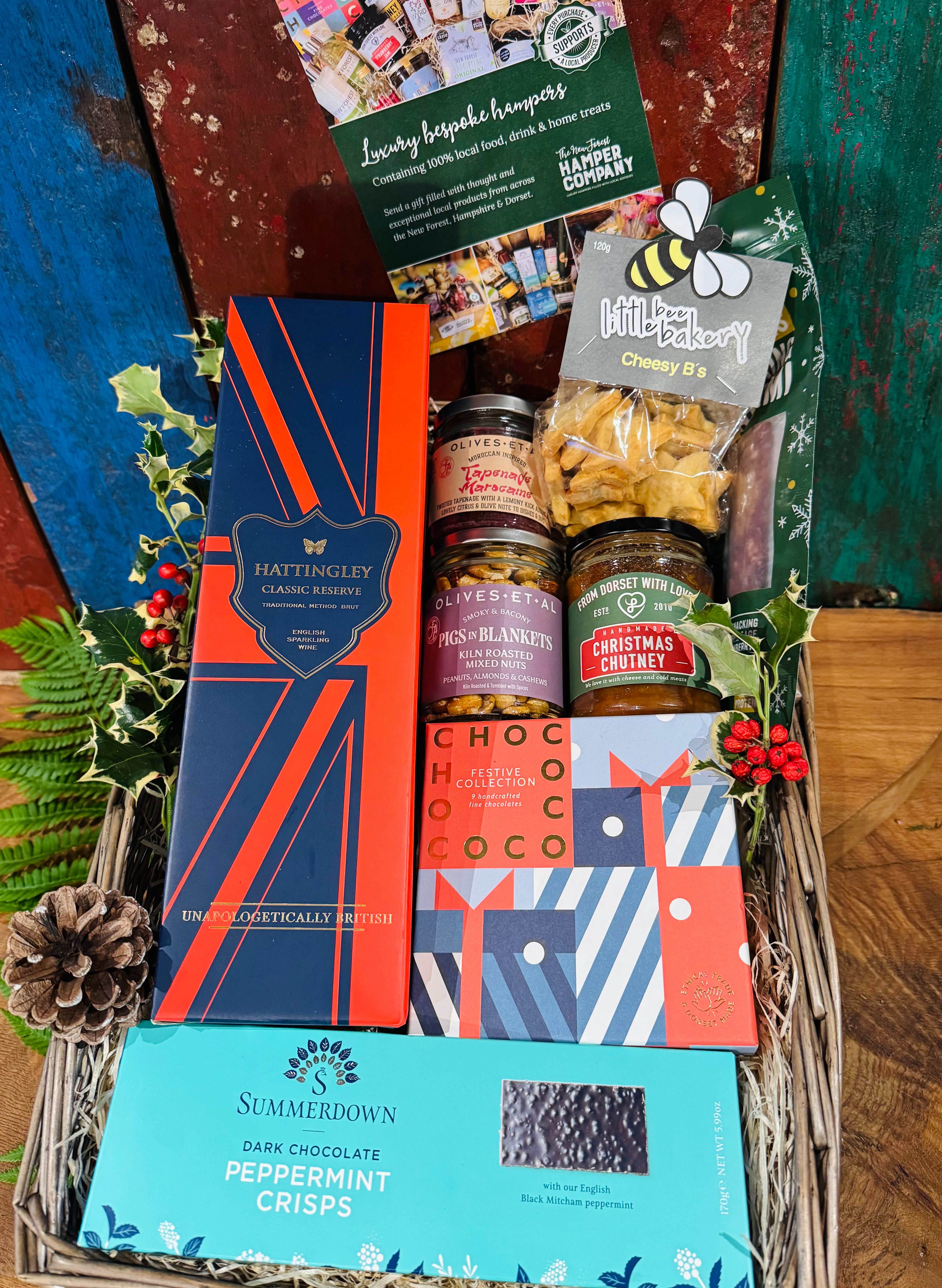 The Hattingley Festive Indulgence Hamper packed in its extra-large antique willow basket with holly, ferns and pine cones