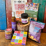 Dorset Giftbox contents laid out with Real Cure Hartgrove Coppa, Chococo handcrafted chocolates, Olives et Al Reganas crackers and Dorset preserves