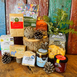 Festive Hampshire Giftbox styled with pine cones, San-Tea Claus Christmas tea, Little Bee Bakery cheesy stars and New Forest Shortbread Original