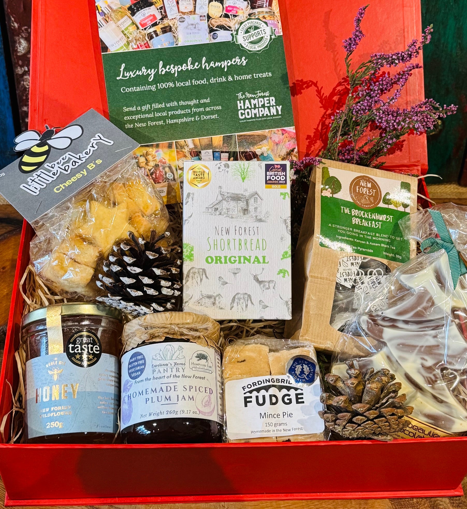 Close-up of the New Forest Festive Favourites Giftbox, showing the Original shortbread, Noble Bee wildflower honey and Fordingbridge mince pie fudge in their red gift box