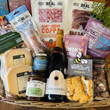 The Perfect Evening In Hamper in an extra large antique willow basket with Chalkdown sparkling rose, Lyburn cheeses, Real Cure Dorset charcuterie, olives, crackers and chocolate honeycomb