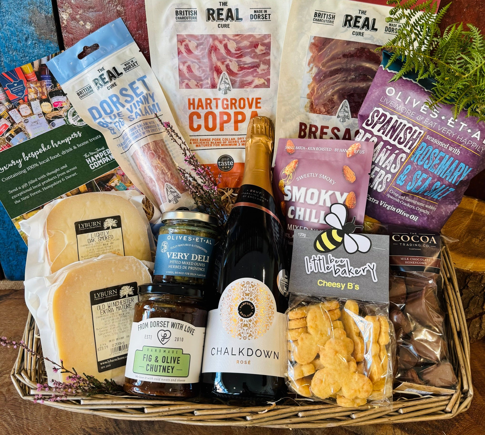 The Perfect Evening In Hamper in an extra large antique willow basket with Chalkdown sparkling rose, Lyburn cheeses, Real Cure Dorset charcuterie, olives, crackers and chocolate honeycomb