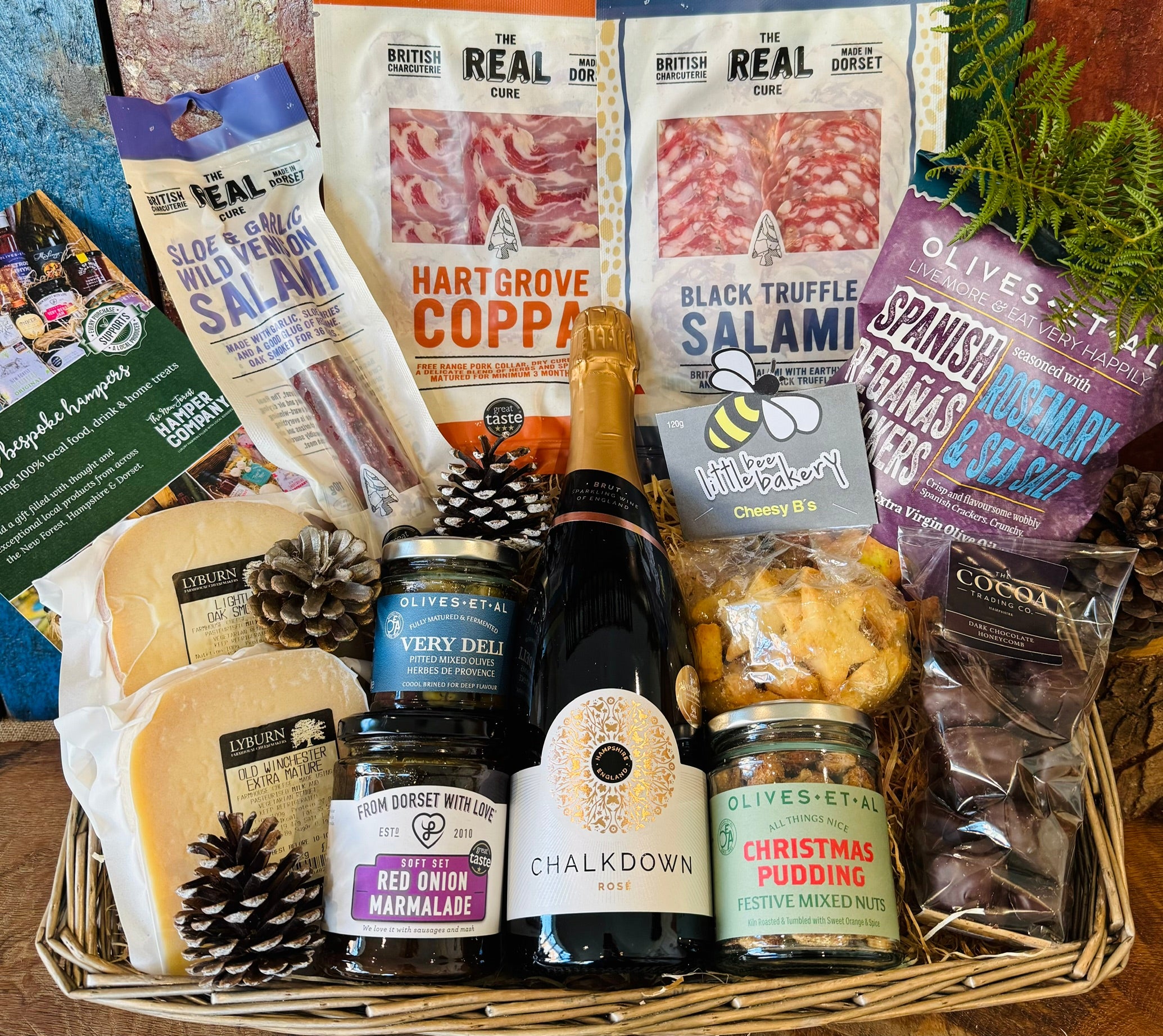 The Perfect Festive Evening In hamper in an extra large antique willow basket with Chalkdown sparkling rose, Dorset charcuterie, Lyburn cheeses, Christmas pudding nuts and dark chocolate honeycomb