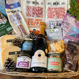 Festive hamper basket styled with pine cones, Hartgrove coppa, black truffle salami, wild venison salami, Lyburn cheeses, red onion marmalade and Cheesy Stars