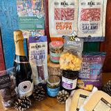 The Perfect Festive Evening In contents laid out with Chalkdown Hampshire sparkling rose, Dorset charcuterie, Reganas crackers, festive mixed nuts and Lyburn farmhouse cheeses