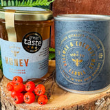 The Noble Bee New Forest wildflower honey with its three star Great Taste award, beside the Noble Bee beeswax and coconut wax candle, both made in the New Forest