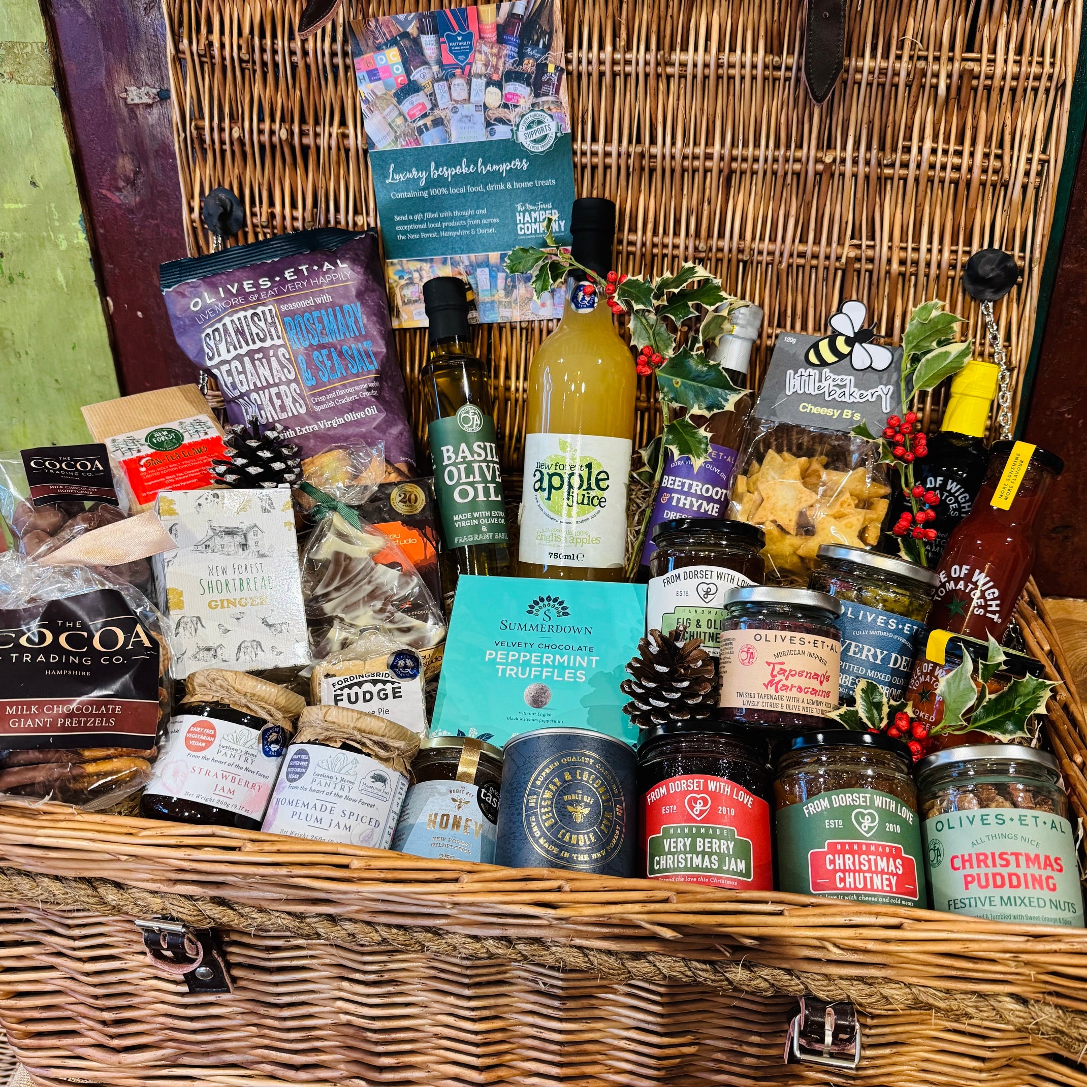The Ultimate Christmas Goodies Hamper - a 24 inch lidded willow basket filled with twenty-eight festive items, with no alcohol and no meat: Cheesy Stars, Spanish Reganas crackers, Herbes de Provence olives, Moroccan tapenade, Christmas chutney and marmalade, chocolates, mince pie fudge, San-Tea Claus tea and a Noble Bee Christmas Spice candle