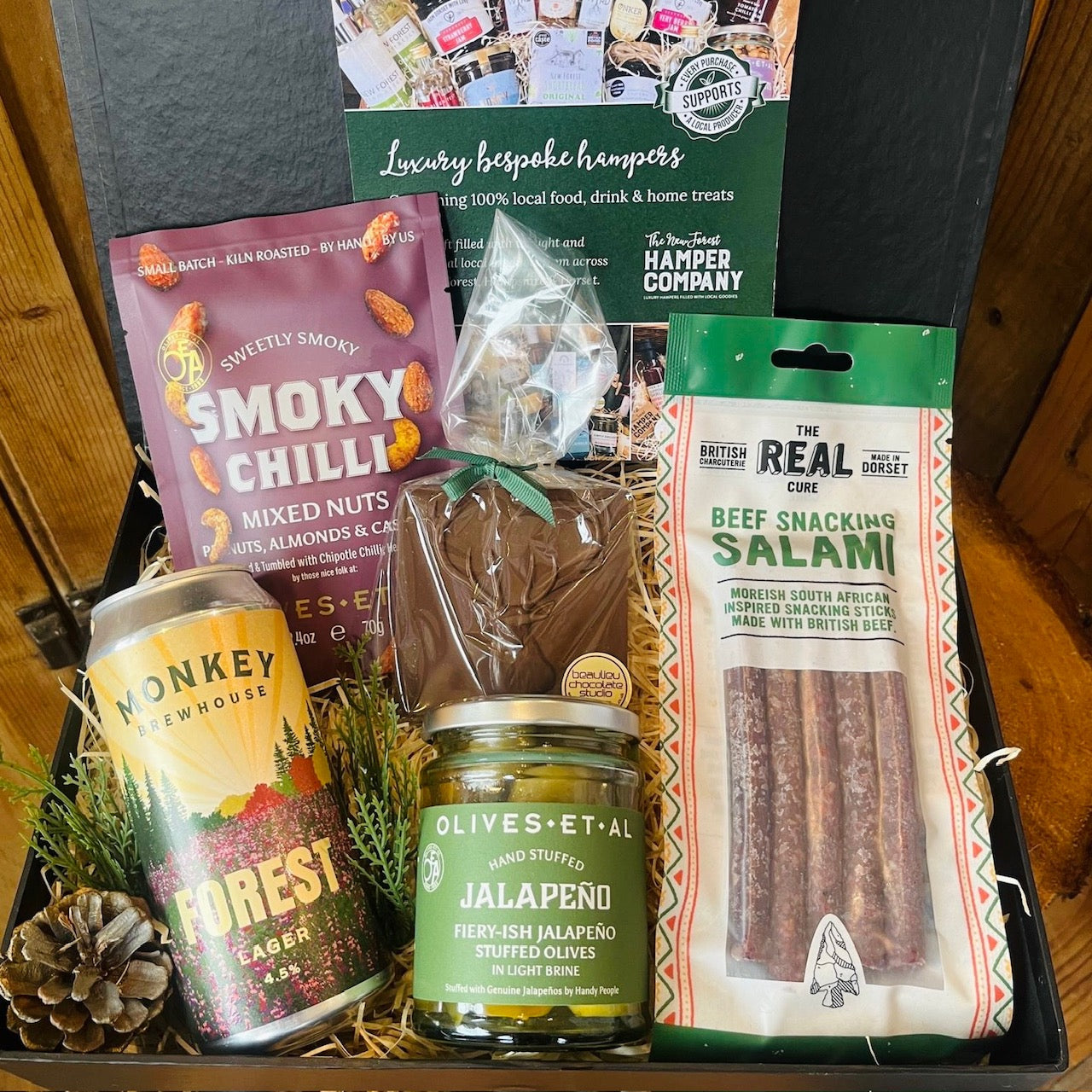 Weekend Wind-Down Gift Box featuring Monkey Brewhouse Forest Lager, Olives et Al smoky chilli nuts and Jalapeño stuffed olives, Real Cure beef snacking salami and Beaulieu Chocolate Studio handmade chocolate from local producers