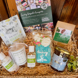 Uplifting Moments Hamper with New Forest Aromatics body care, Revive candle, New Forest tea, New Forest Shortbread, Noble Bee wildflower honey and a Little Bee Bakery hand-iced 'Thinking of You' biscuit.